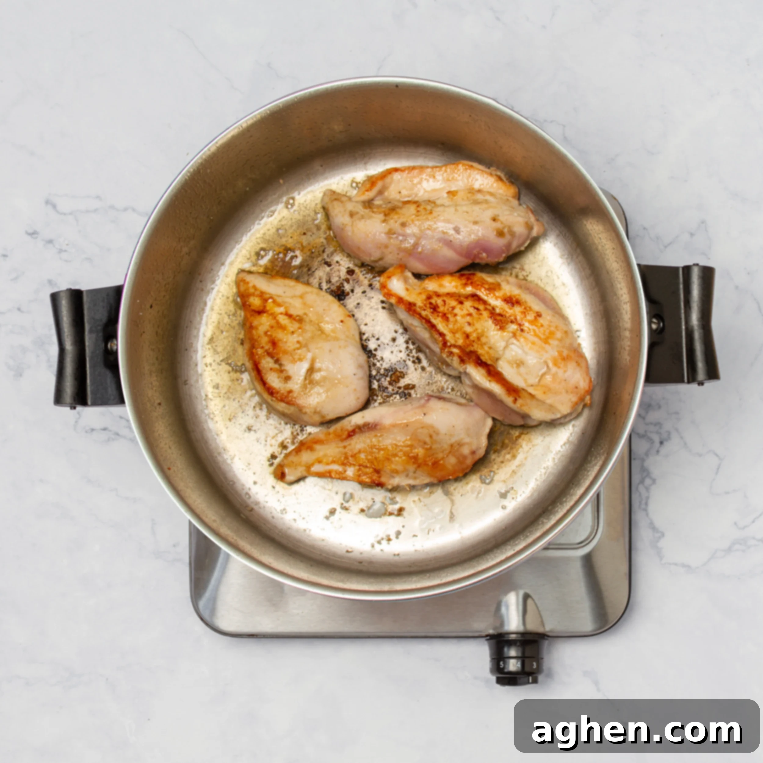 Tropical Coconut Lime Chicken 4 Seasoned chicken breasts cooking in a hot skillet, achieving a golden-brown sear.