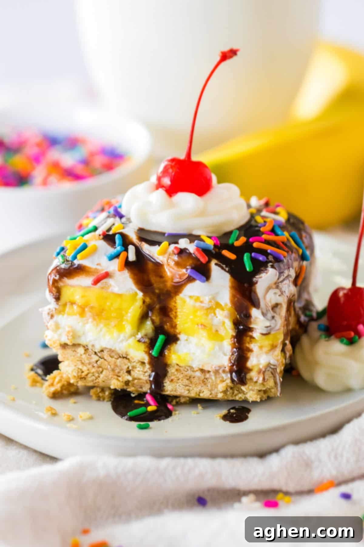 Ultimate No-Bake Banana Split 2 No bake banana split dessert with a graham cracker crust; layers of sweetened cream cheese, banana pudding, and Cool Whip; and topped with chocolate syrup, whipped cream, and a cherry.