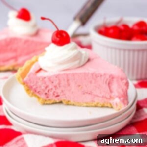 No-Bake Kool-Aid Dream Pie 12 Slice of cherry cool aid pie on white plate with large glass of milk in the background.