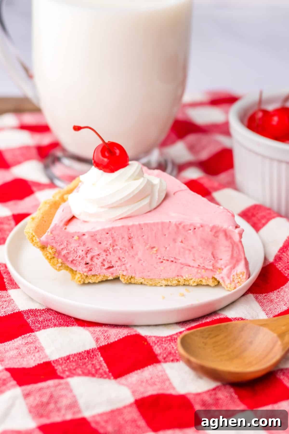 No-Bake Kool-Aid Dream Pie 10 Slice of cherry cool aid pie on white plate with large glass of milk in the background.