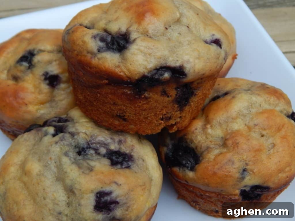 A beautifully arranged stack of golden blueberry lemon yogurt muffins on a plate