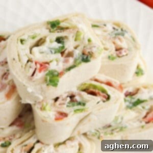 Creamy Ranch BLT Swirls 9 Ranch BLT Pinwheels made with flour tortillas, bacon, lettuce, tomatoes, and ranch dressing stacked on a white plate.