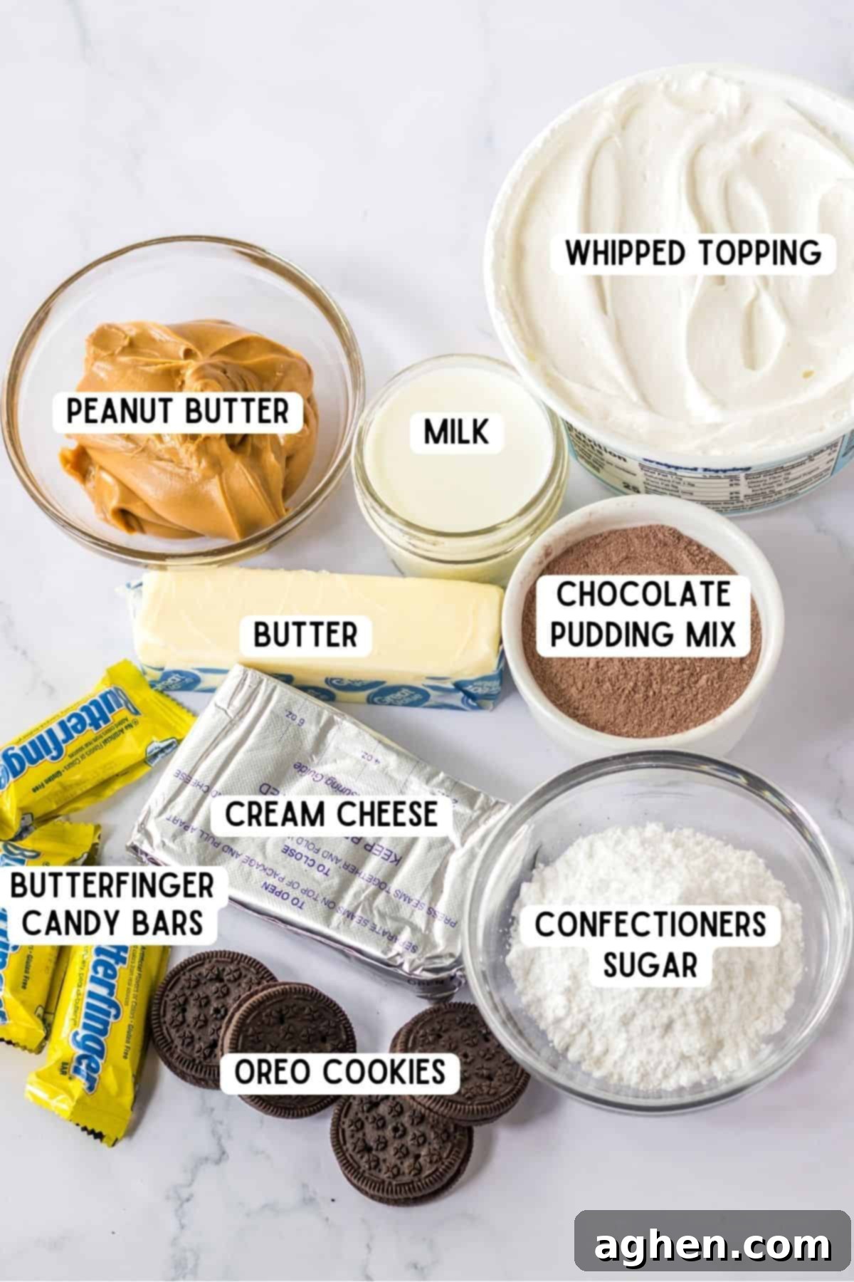 Butterfinger Crunch Layer Dream 3 A flat lay of all the essential ingredients for Butterfinger Lush: a tub of Cool Whip, a stick of butter, a glass of milk, a block of cream cheese, a handful of mini Butterfinger bars, a stack of Oreo cookies, and small bowls filled with confectioners' sugar, creamy peanut butter, and instant chocolate pudding mix.