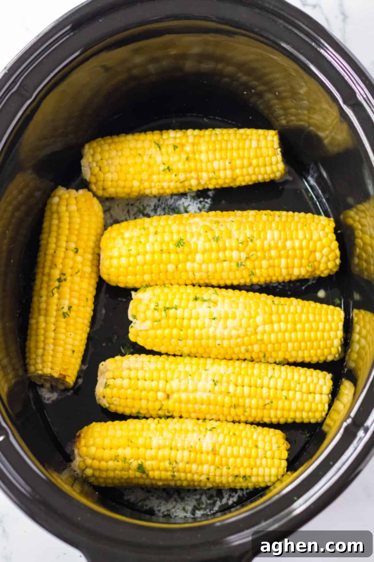 Effortless Slow Cooker Corn 7 Slow cooker corn on the cob with butter and seasonings.