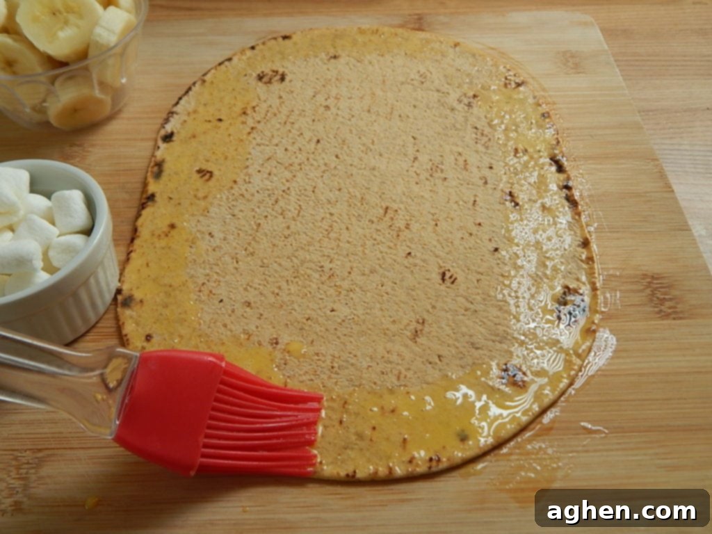 A Flatout bread with egg wash brushed around the edges, ready for filling.