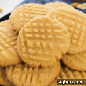 Batch of cake mix peanut butter cookies with criss-cross pattern pressed in the top.