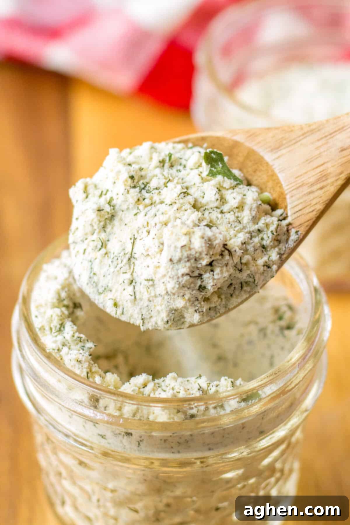 Homemade Ranch Seasoning Mix 5 Small wooden spoon lifting ranch seasoning mix out of jar.