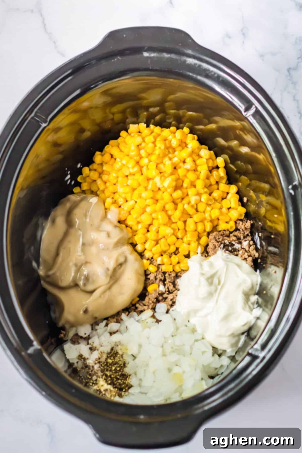 Effortless Tater Tot Comfort 5 Ground beef, corn, soup, onion, seasonings, milk, and sour cream added to crockpot.