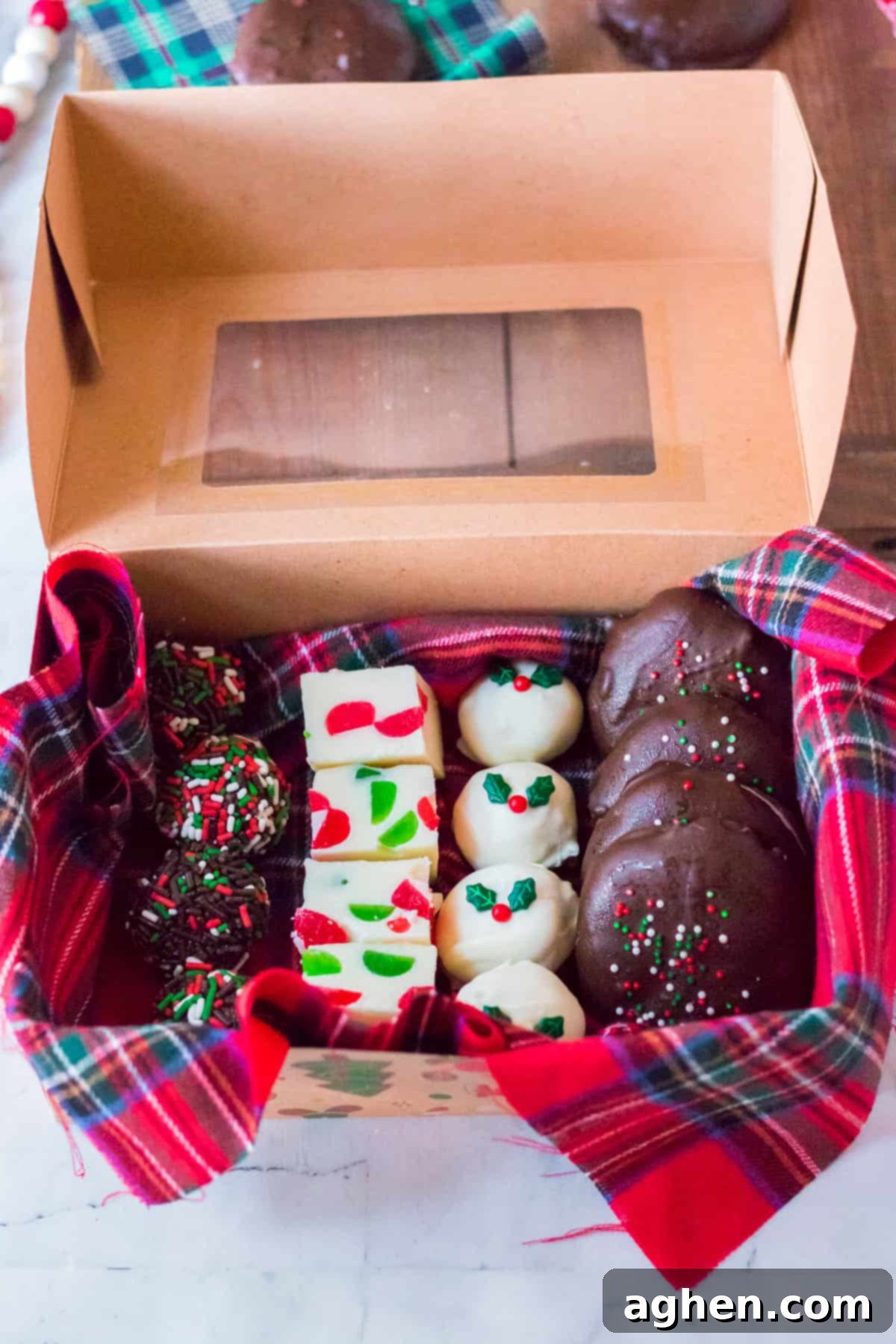 Box of homemade Christmas candy ready for gifting. Contains: rum balls, gumdrop fudge, gingerbread truffles, and homemade peppermint patties. A charming gift box filled with an assortment of handcrafted Christmas candies, perfect for spreading holiday cheer.