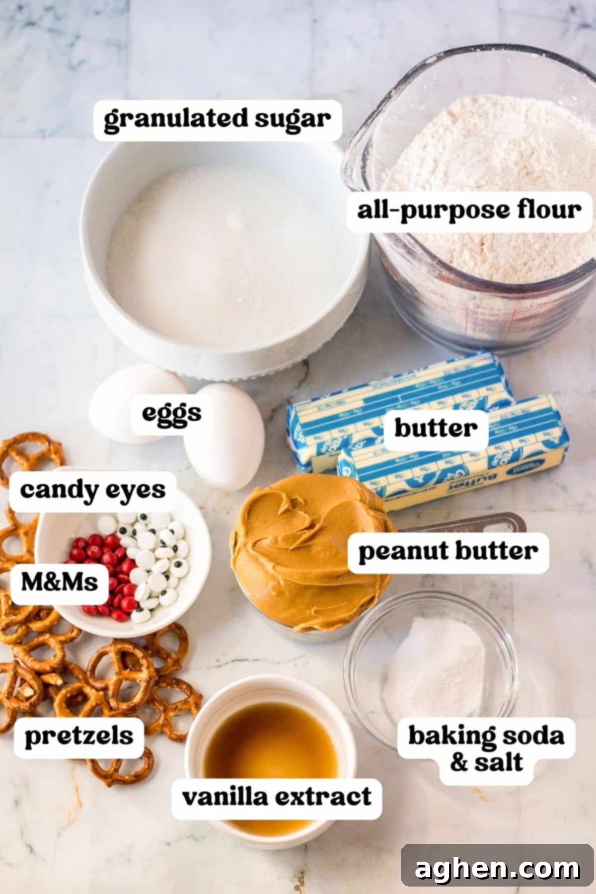 Reindeer cookie ingredients: granulated sugar, all-purpose flour, butter, peanut butter, eggs, pretzels, vanilla extract, baking soda, salt, candy eyes, and red M&Ms.