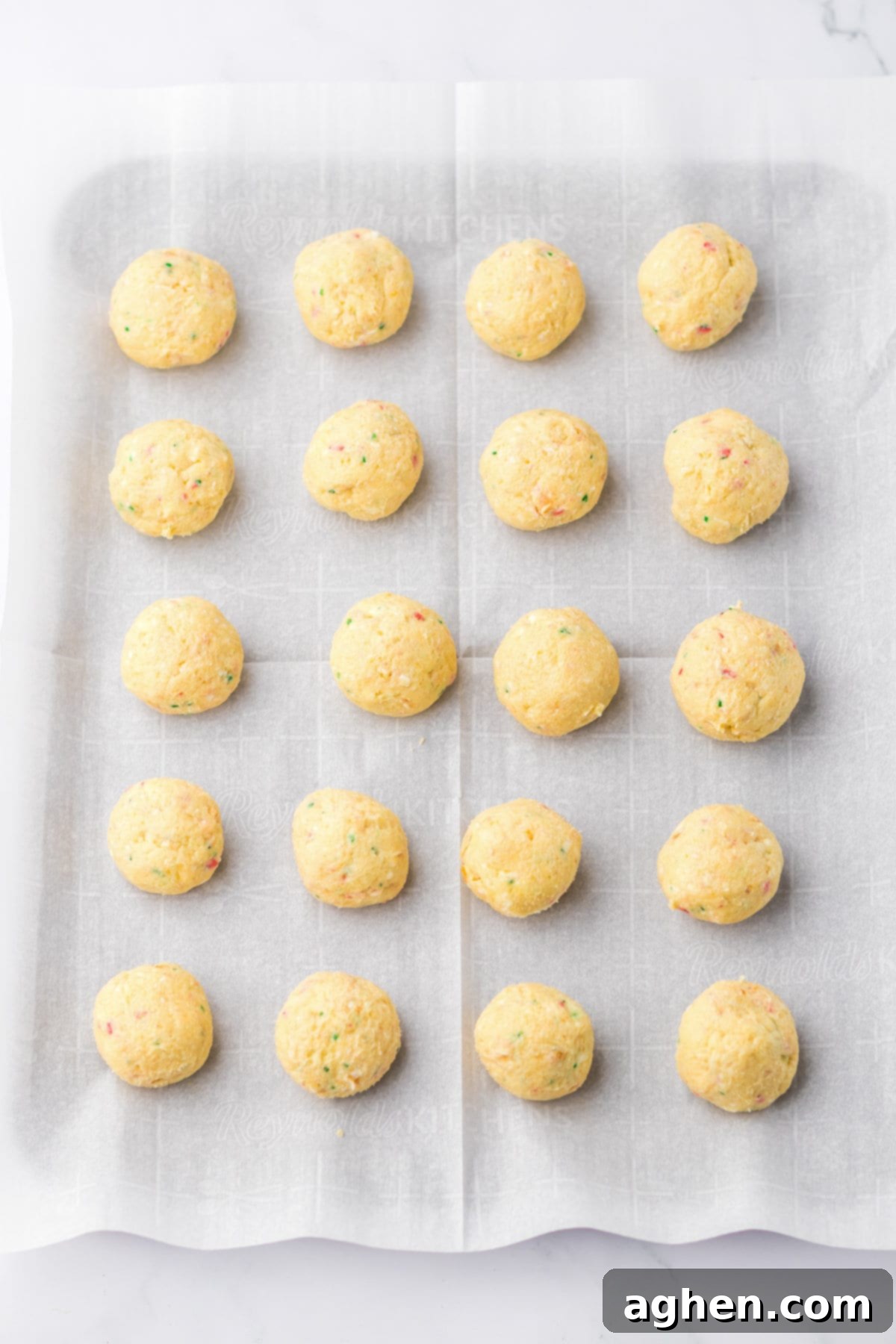 Perfectly rolled 1-inch dough balls arranged neatly on a lined baking sheet, ready for chilling.