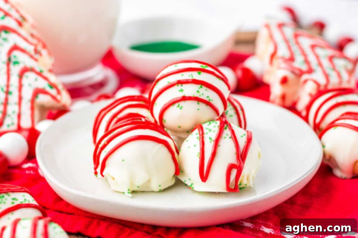 A festive white plate laden with homemade Little Debbie Christmas Tree Cake Balls, surrounded by actual Christmas Tree Cakes, creating a delightful holiday dessert display.
