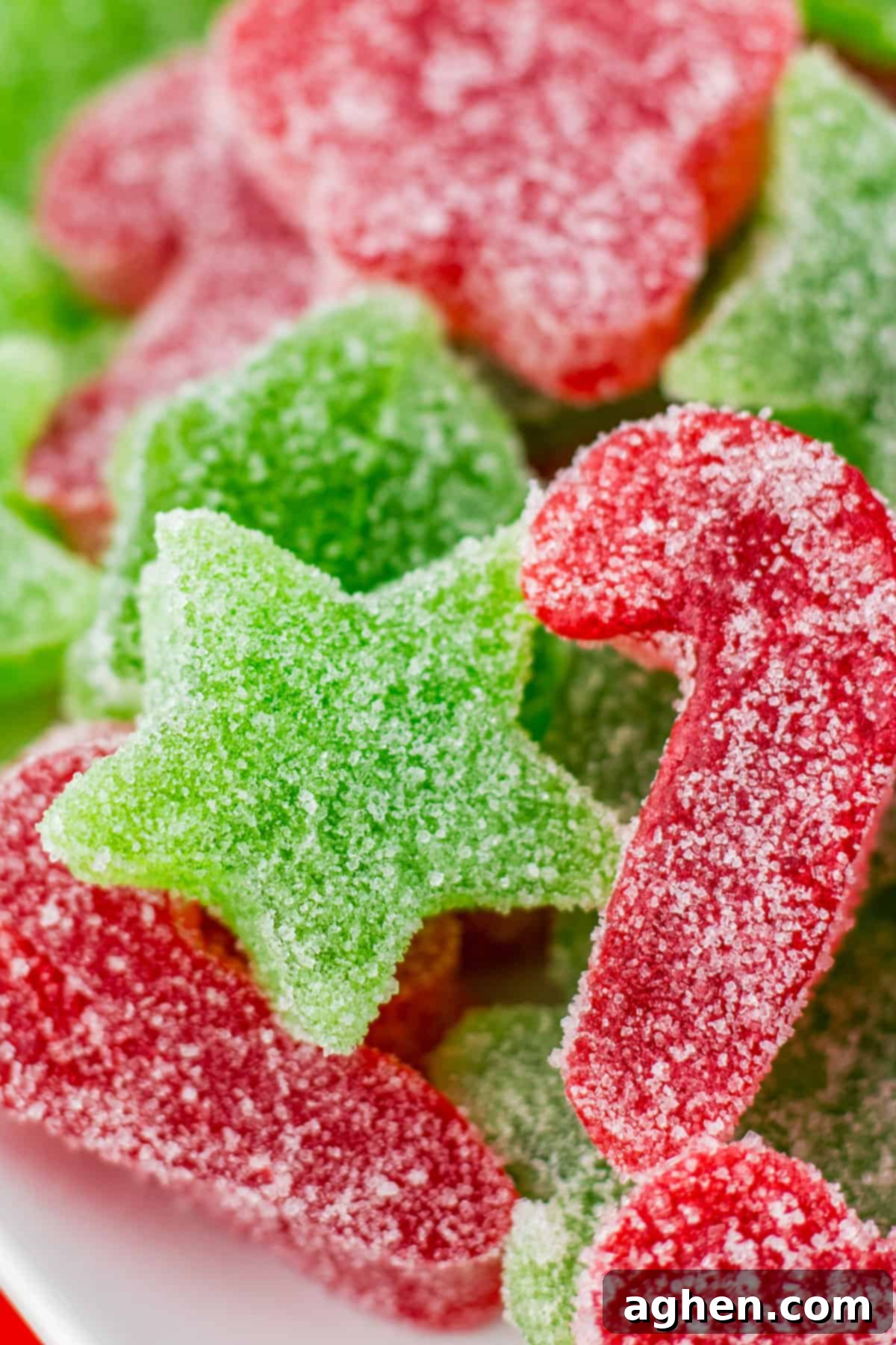 Close up of a green star gumdrop and a red candy cane gumdrop.