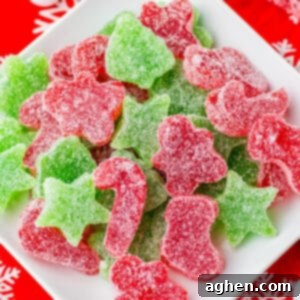 Homemade red and green Christmas gumdrops cut into christmas shapes and piled on a white plate.