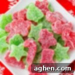 Homemade red and green Christmas gumdrops cut into christmas shapes and piled on a white plate.