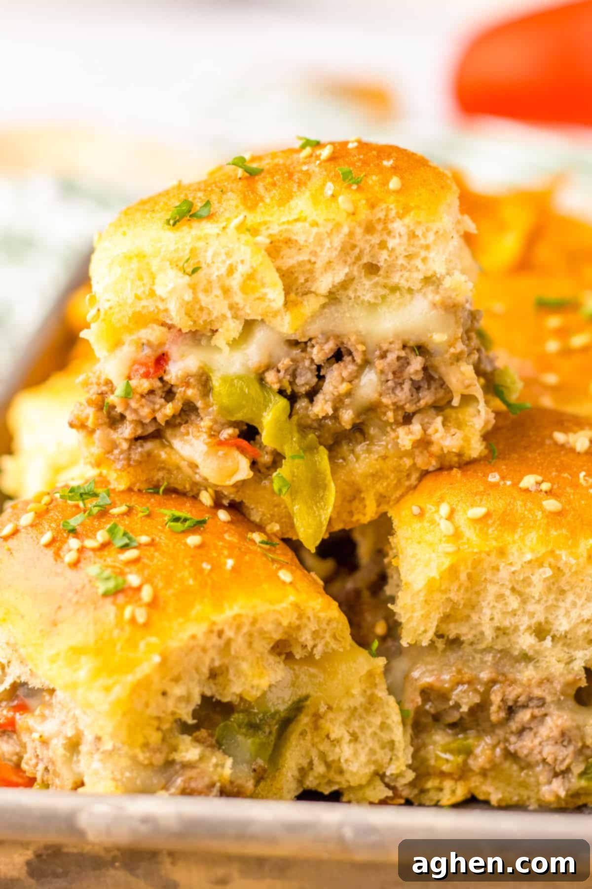 Bite-Sized Philly Cheesesteak Bliss 2 Philly Cheesesteak Sliders with Ground Beef, peppers, onions, and provolone cheese on Hawaiian Rolls.