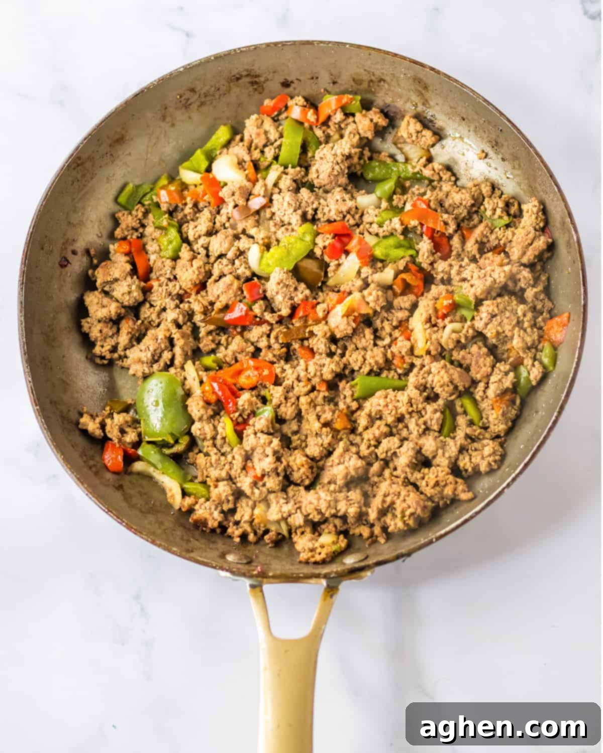 Bite-Sized Philly Cheesesteak Bliss 5 Browned ground beef, peppers, and onions in a frying pan.