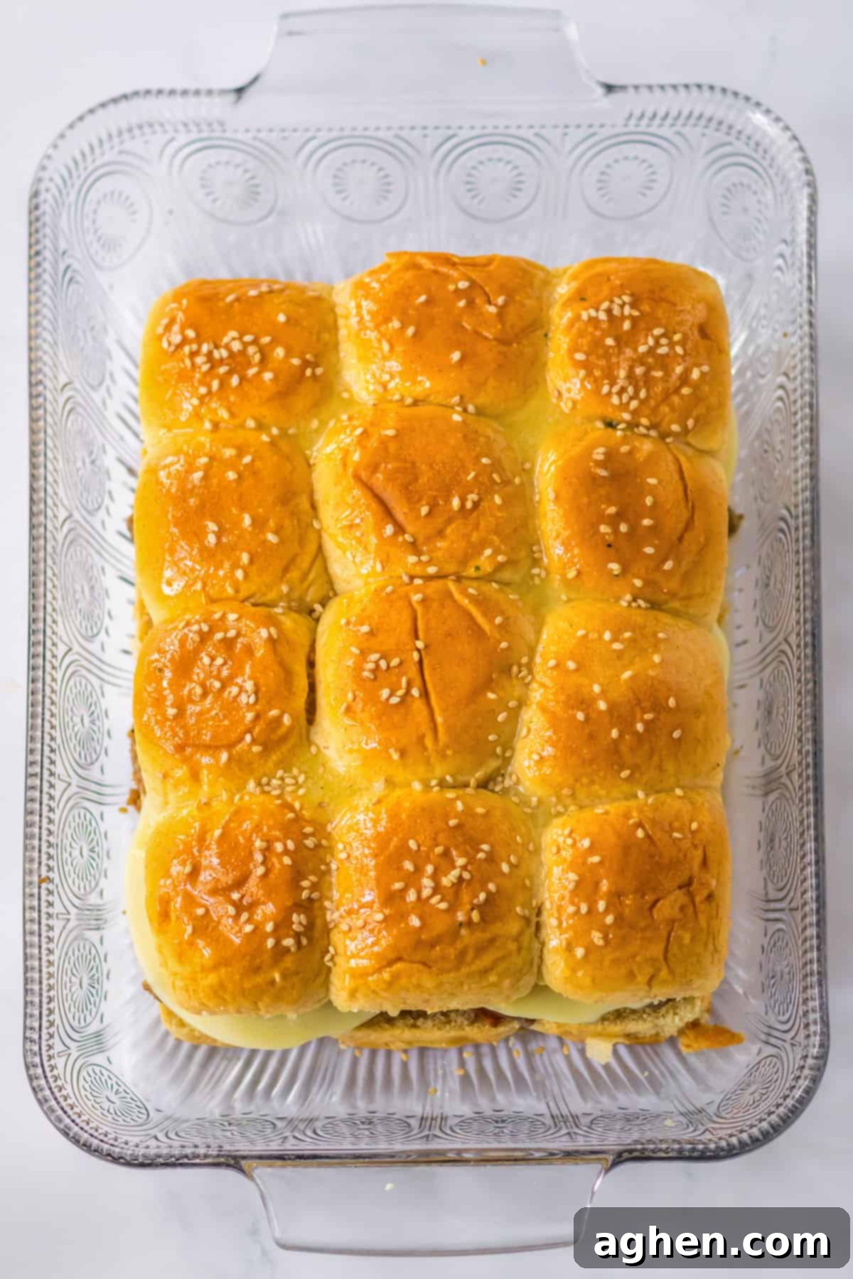 Bite-Sized Philly Cheesesteak Bliss 8 Slider buns with sesame seeds in 9 x 13 casserole dish, ready for baking.