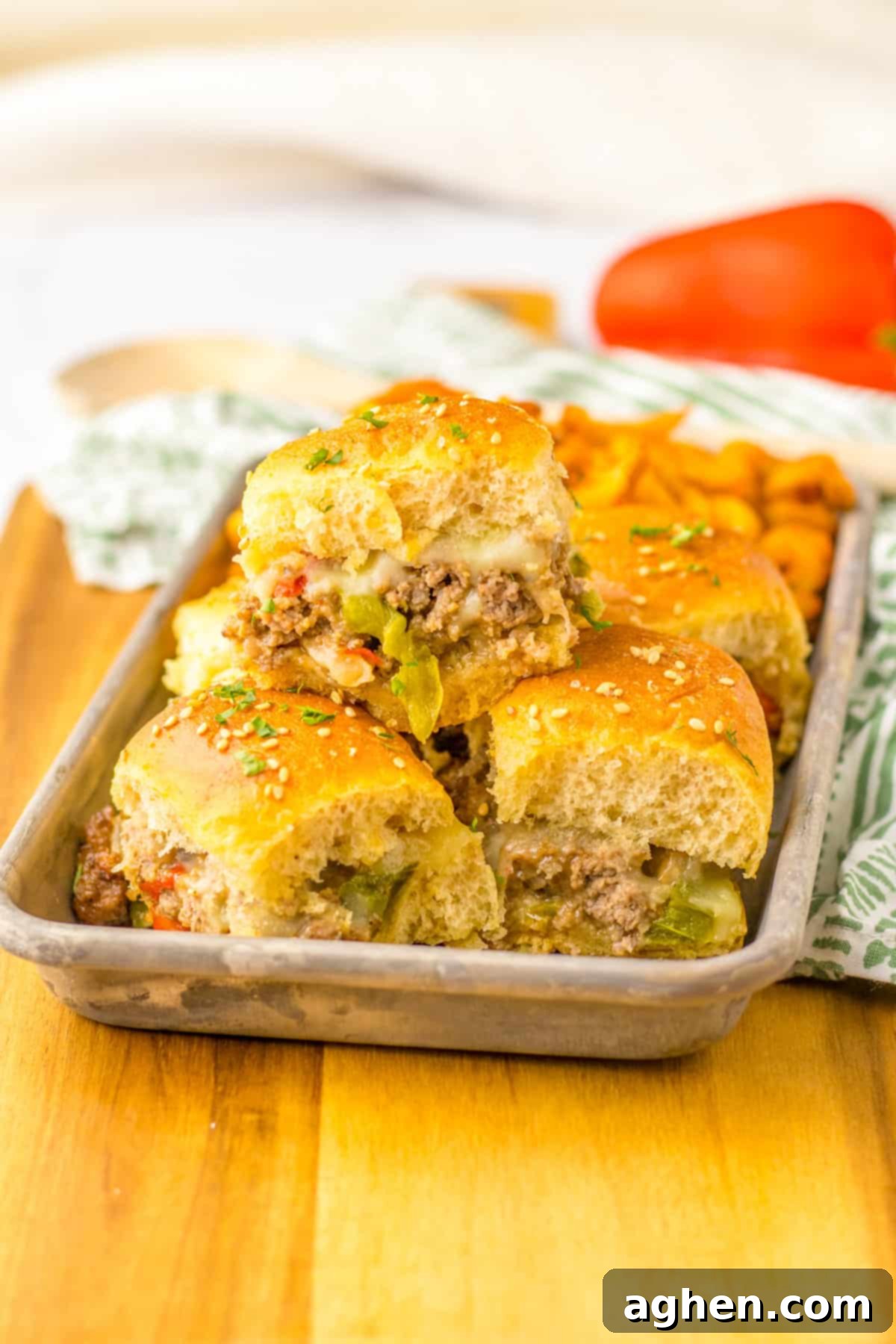 Bite-Sized Philly Cheesesteak Bliss 10 Ground Beef Philly Cheesesteak Sliders with peppers, onions, and provolone cheese on Hawaiian Rolls served with seasoned french fries.