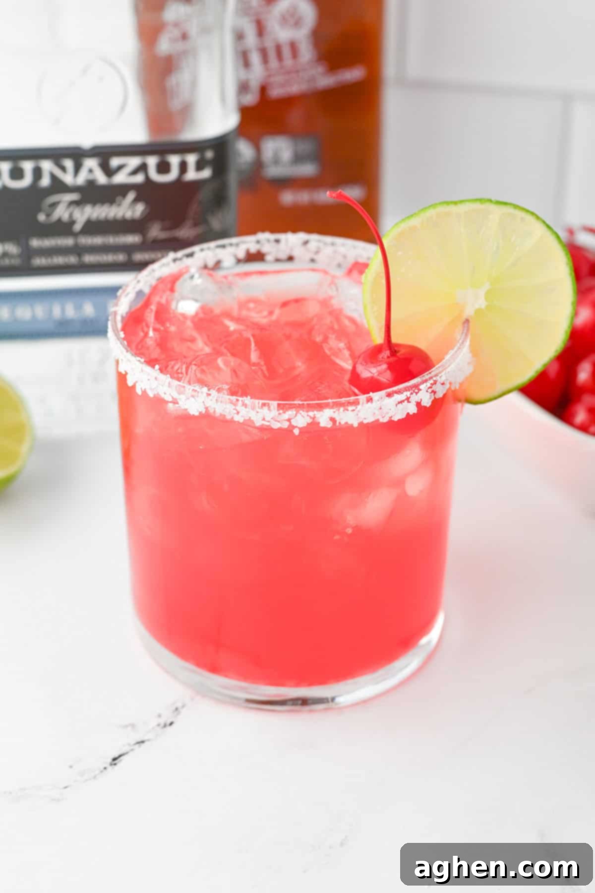 Blush Margarita 5 Pink margarita on the rocks with salt, lime and maraschino cherry garnish.