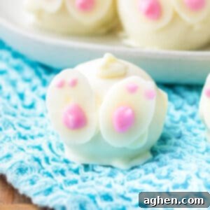 Delightful Oreo cookie truffles, elegantly dipped in white chocolate and charmingly decorated with white chocolate feet and a whimsical swirly tail to resemble cute little bunny butts, perfect for Easter.
