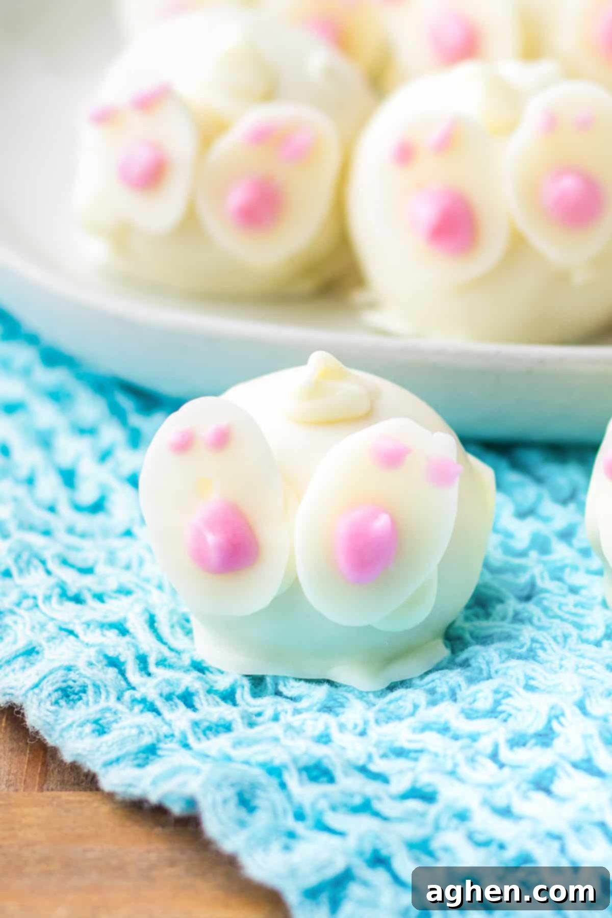 Close-up of an Easter bunny white chocolate truffle, intricately decorated with delicate pink details on its feet, ready for serving.