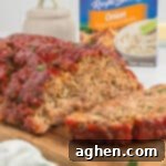 Lipton Onion Soup Mix Meatloaf with ketchup glaze and box of Lipton soup mix packets.