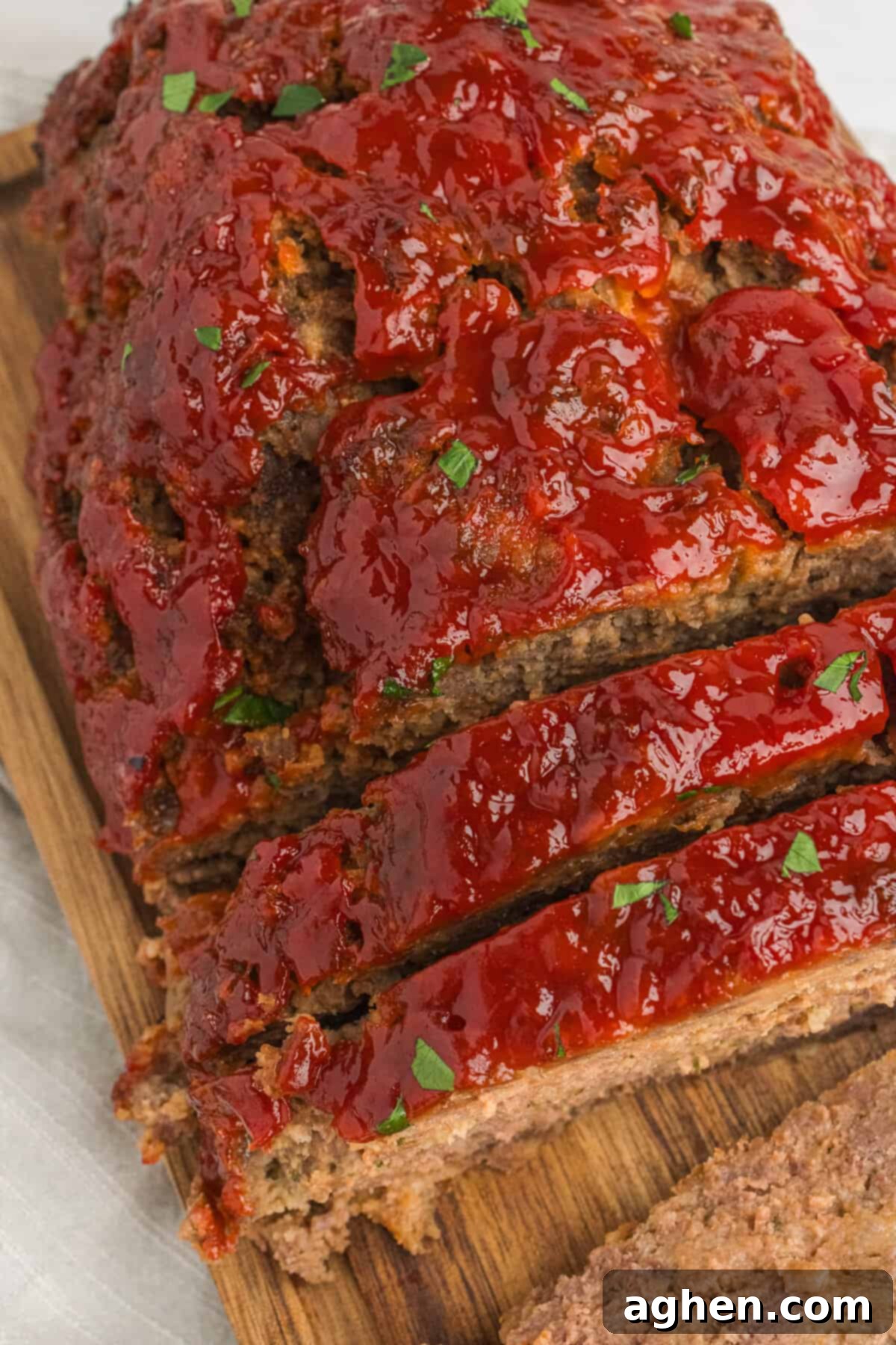Meatloaf on cutting board, half has been sliced.