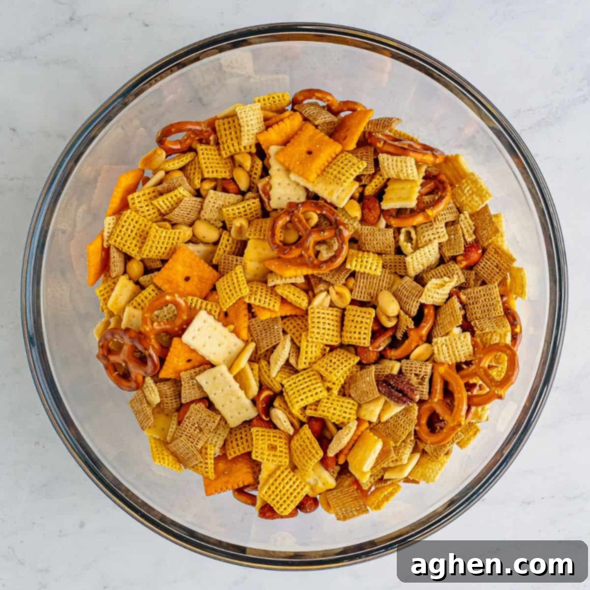 Zesty Crunch Medley 4 Chex cereal, mini pretzels, cheeze-its, mini club crackers, and mixed nuts in a mixing bowl.