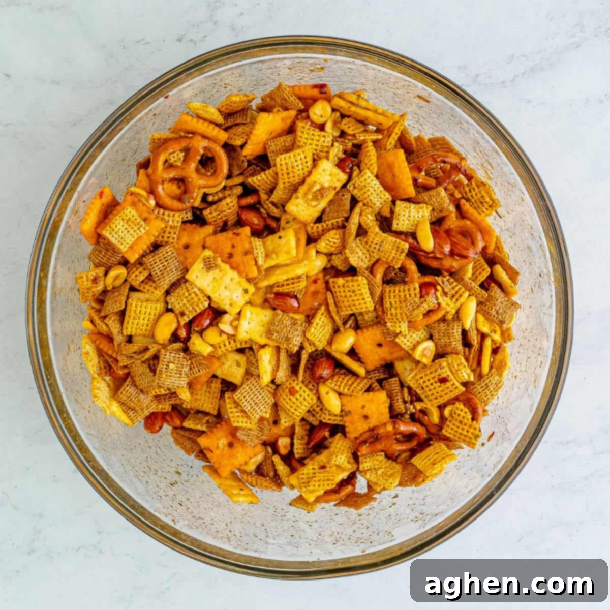 Zesty Crunch Medley 6 Chex mix coated with sauce in a glass mixing bowl.