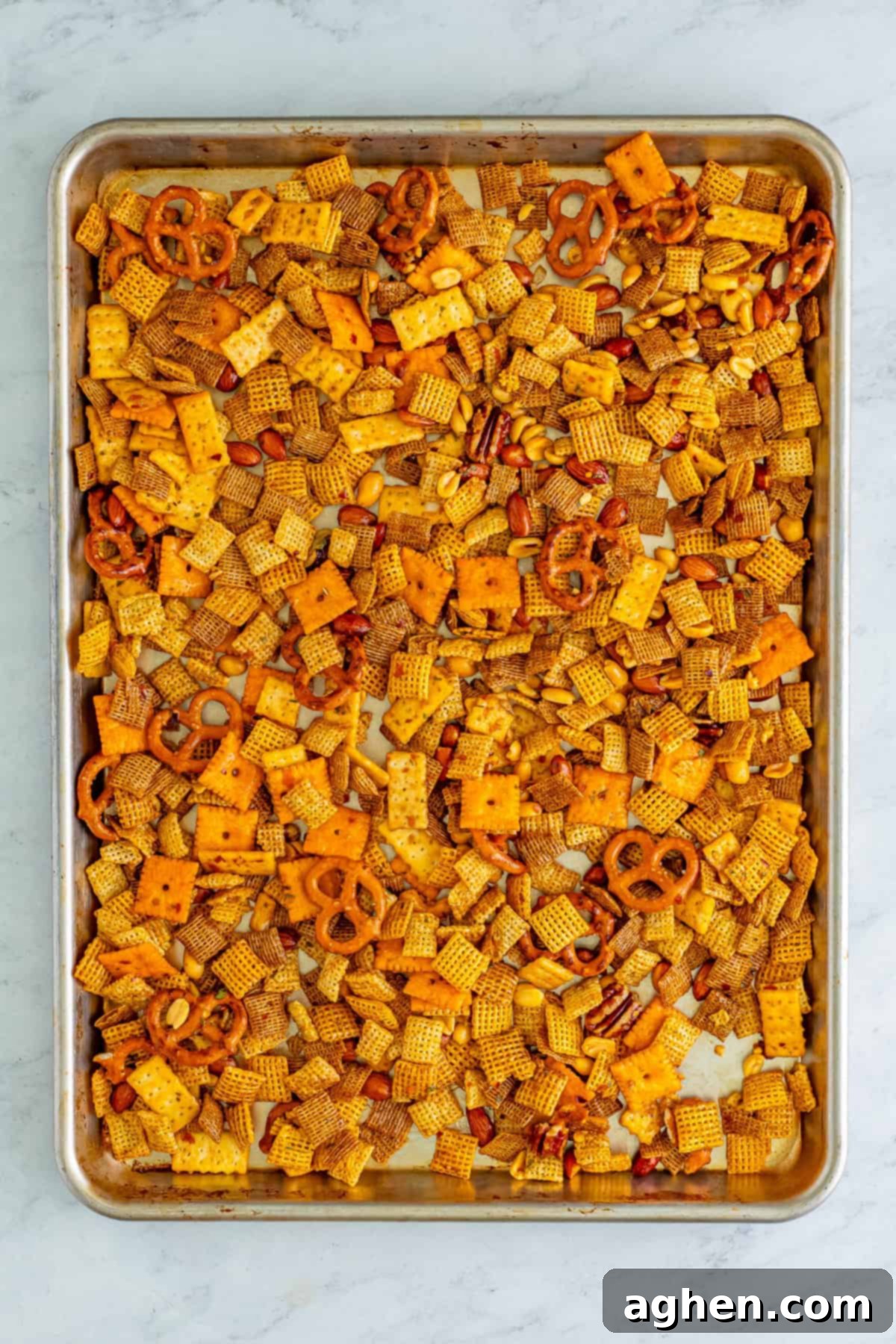 Zesty Crunch Medley 7 Chex mix spread in an even layer on a baking sheet.