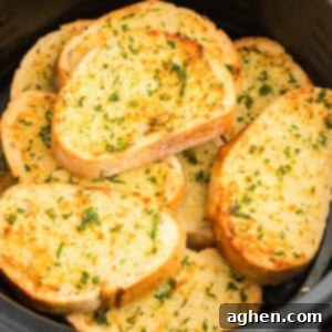Slices of thick garlic bread stacked in air fryer basket.