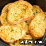 Slices of thick garlic bread stacked in air fryer basket.