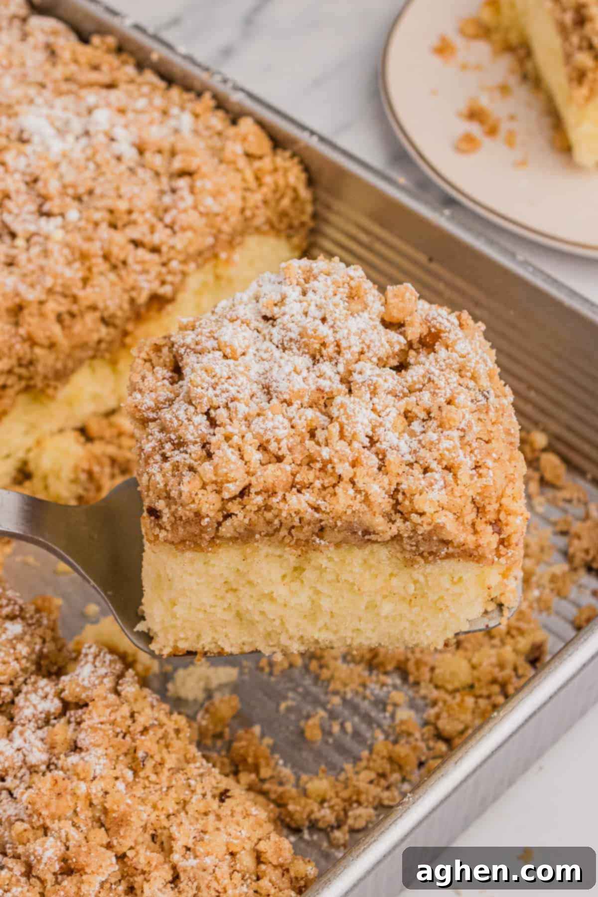Simple Crumb Cake Perfection 9 Slice of cake mix crumb cake being removed from pan with metal spatula.
