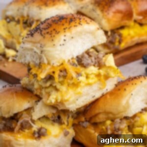 Sweet & Savory Hawaiian Breakfast Bake 11 3 Sausage egg and cheese Hawaiian Roll Breakfast Sliders stacked on top of one another with more in the background, making a delicious breakfast scene.