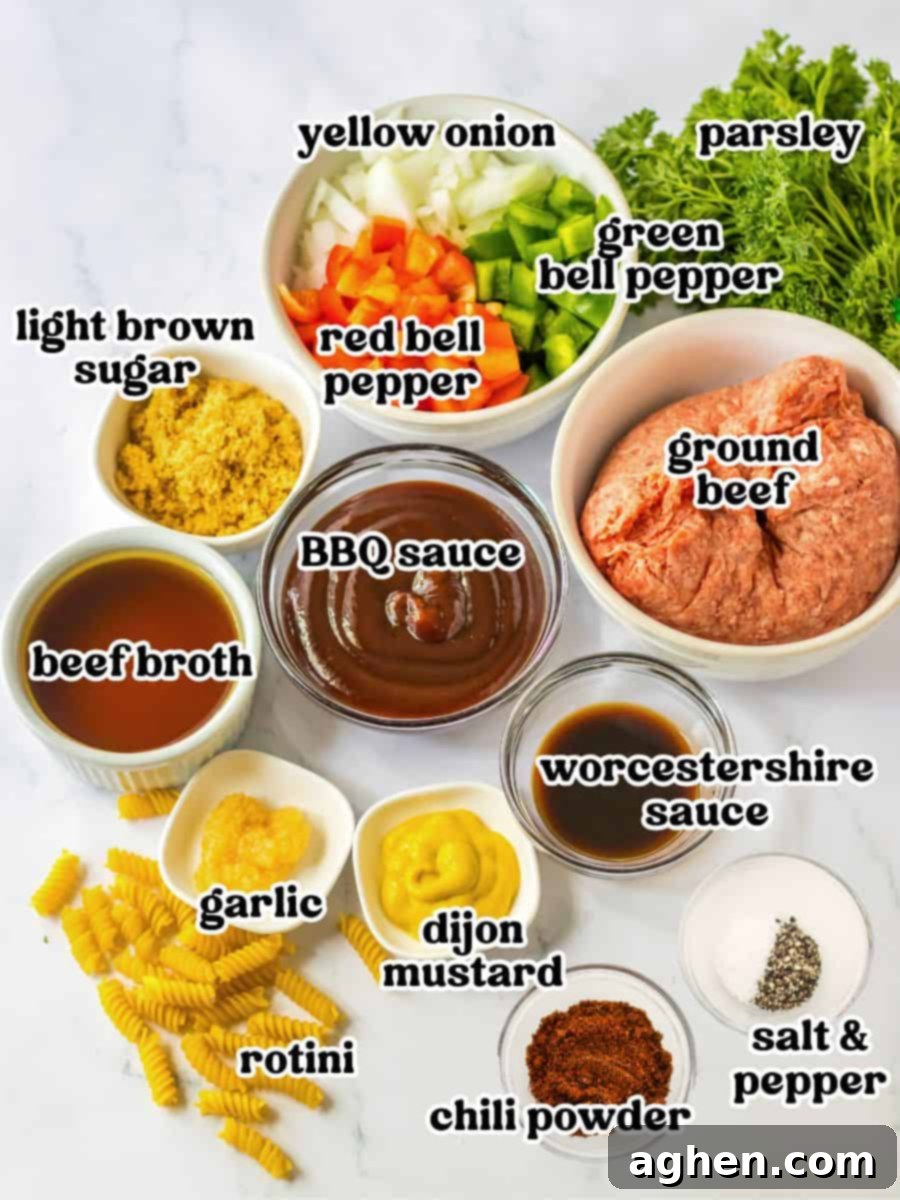 Hearty Sloppy Joe Pasta 4 All the ingredients for Sloppy Joe Pasta laid out: diced yellow onion, red and green bell peppers, minced garlic, ground beef, rotini pasta, chili powder, salt, pepper, Dijon mustard, BBQ sauce, Worcestershire sauce, beef broth, and fresh parsley.