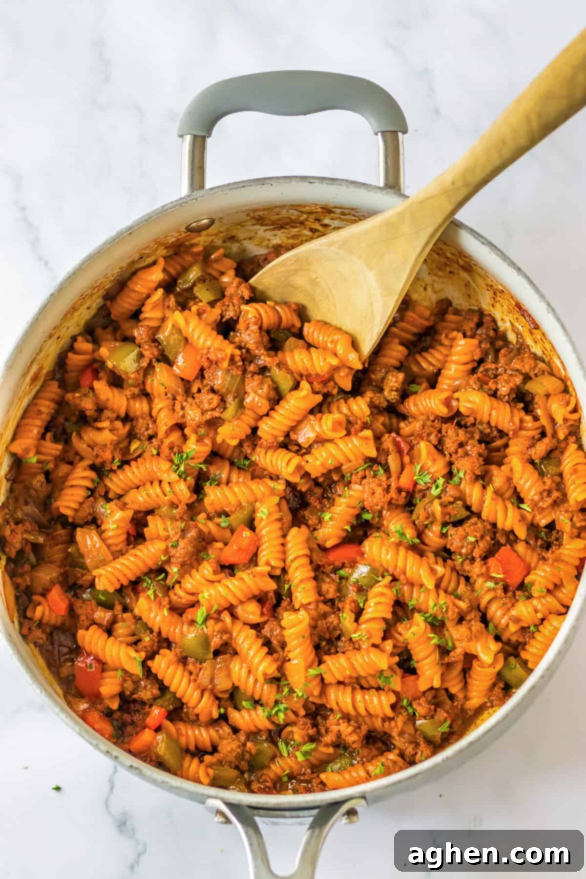 Hearty Sloppy Joe Pasta 6 Close-up of One Pot Ground Beef Pasta, a hearty sloppy joe pasta dish in a skillet with a wooden spoon, ready to be served.