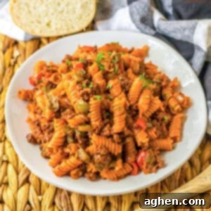 Hearty Sloppy Joe Pasta 10 Sloppy Joe pasta with ground beef and rotini noodles, garnished with fresh parsley and served with sliced bread.