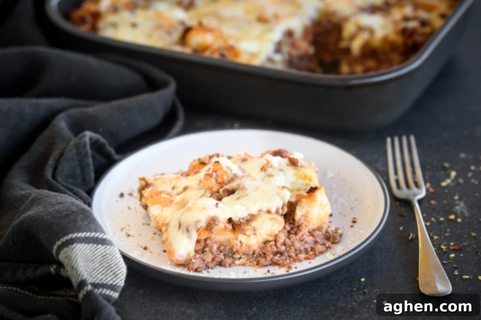 Puffed Lasagna Casserole 2 Freshly baked Bubble Up Lasagna served on a clean white plate, garnished with vibrant fresh parsley, showcasing its appetizing texture and golden crust.
