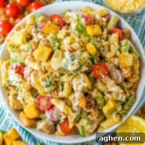 Chicken Caesar Pasta Salad with crisp lettuce, juicy tomatoes, savory Parmesan cheese, crunchy croutons, and a luscious Caesar salad dressing.
