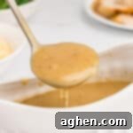 Easy homemade turkey gravy without drippings in spooned out of a gravy boat into a ladle.