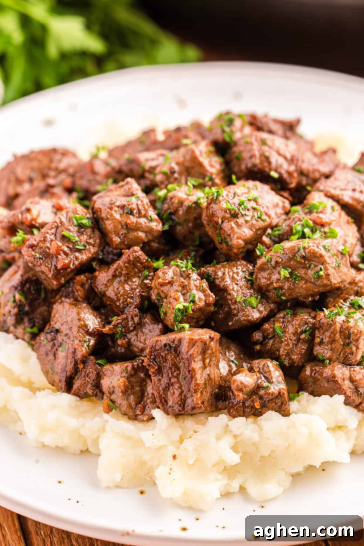 Steak bites with garlic butter served on bed of mashed potatoes.