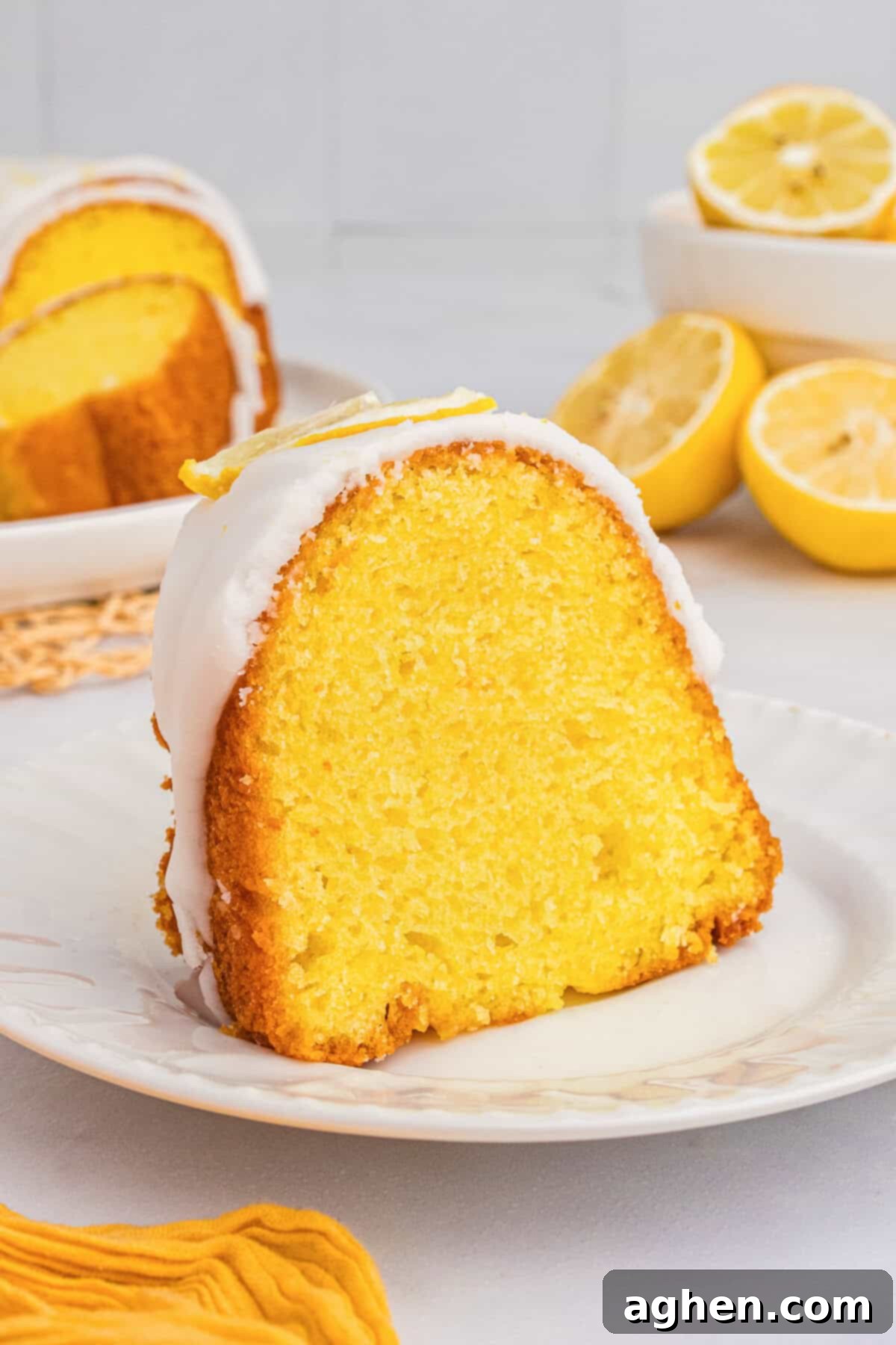 Effortless Lemon Bundt Cake Perfection 7 A delightful slice of moist lemon pudding bundt cake with cake mix, perfectly plated on a white dish, ready to be savored.