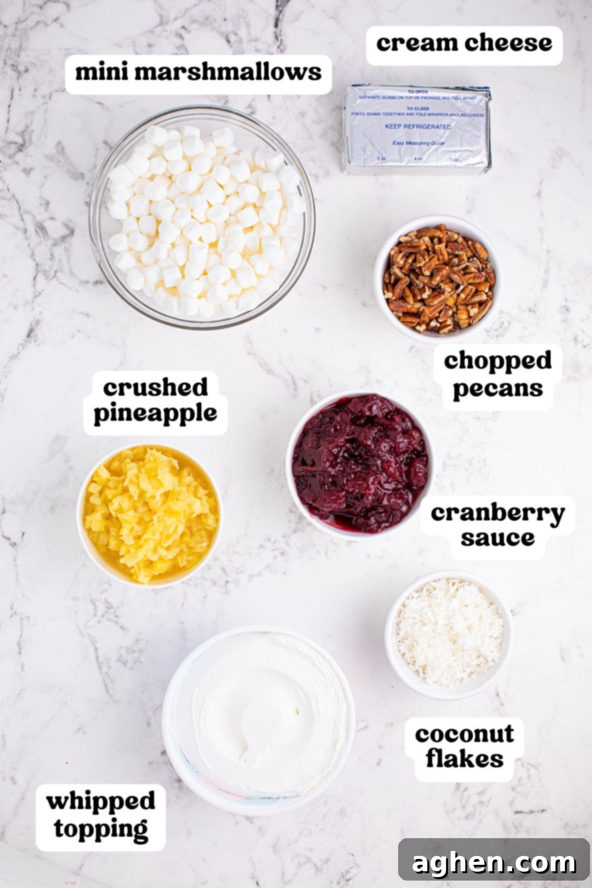 Cranberry fluff ingredients: marshmallows, pineapple, cranberry sauce, cream cheese, whipped topping, coconut, and pecans.