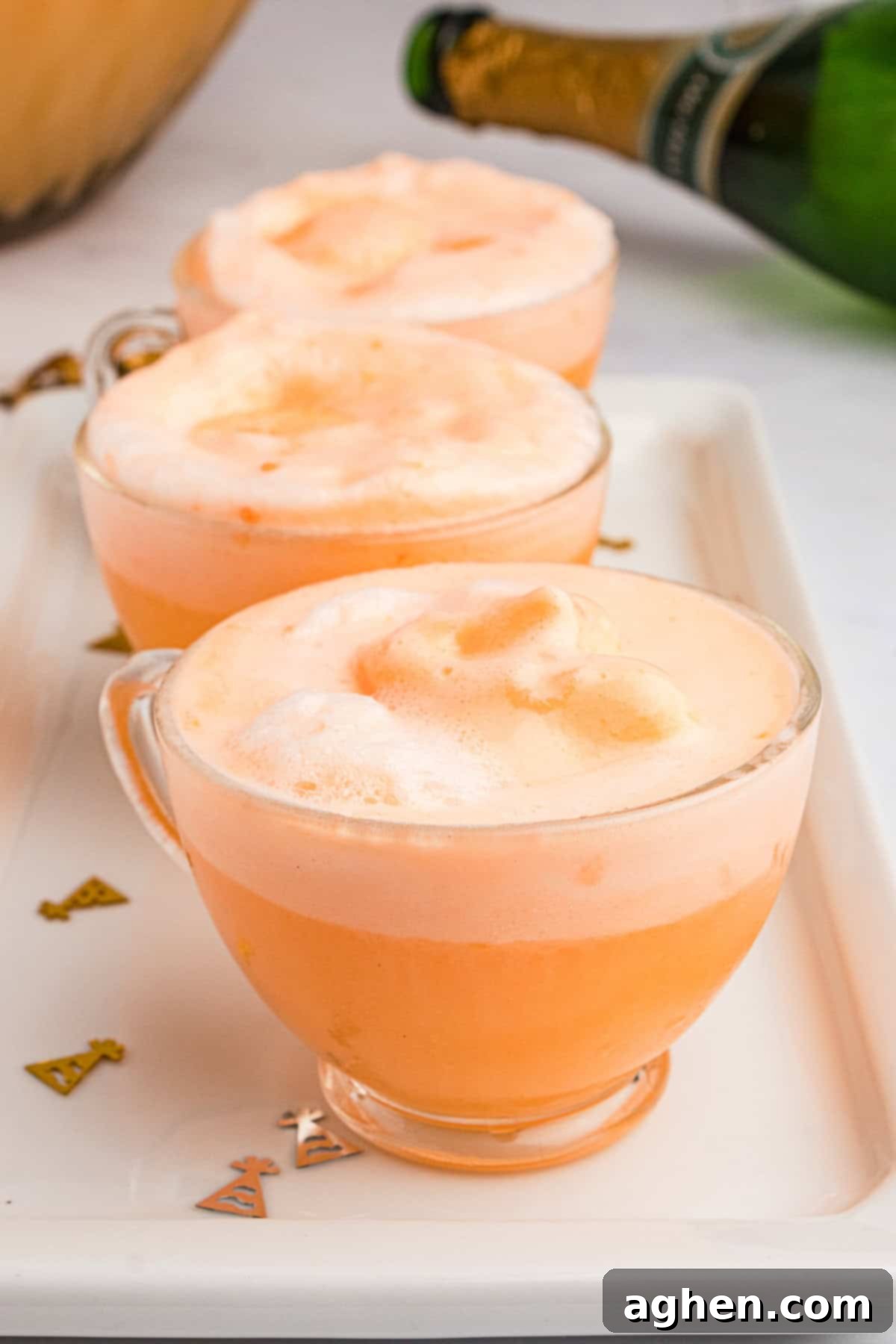 Orange sherbet champagne punch in old fashioned punch glasses.