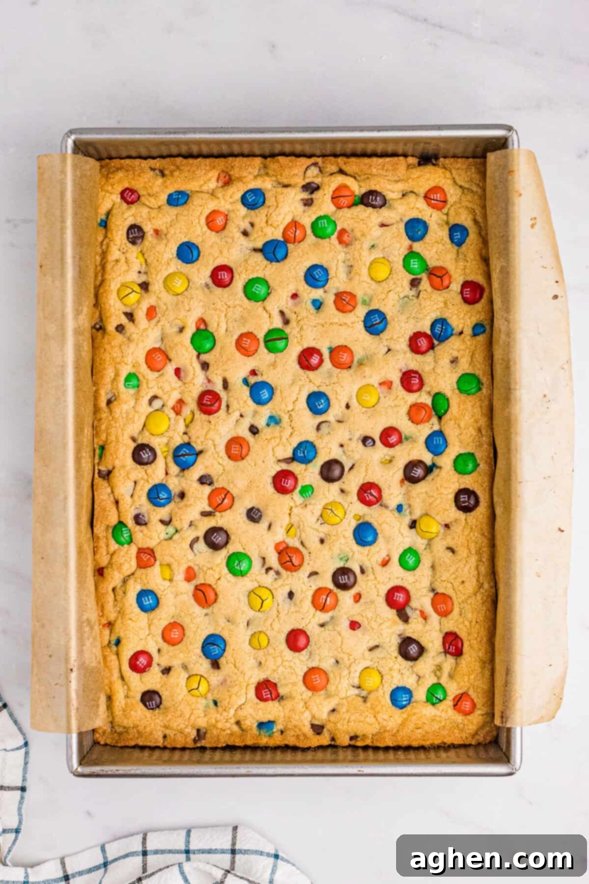 Golden brown M&M cookie bars after baking, still in the 9 x 13 pan, showing a perfectly set top.