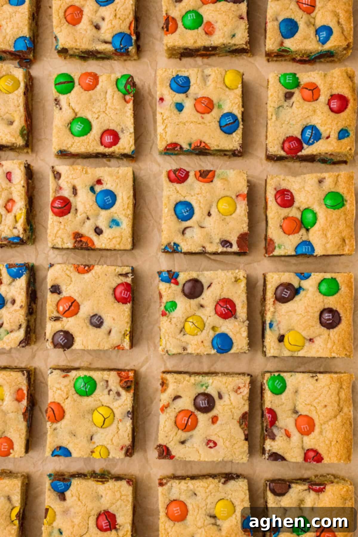 M&M cookie bars with chocolate chips, neatly sliced into squares on parchment paper, ready to be enjoyed.