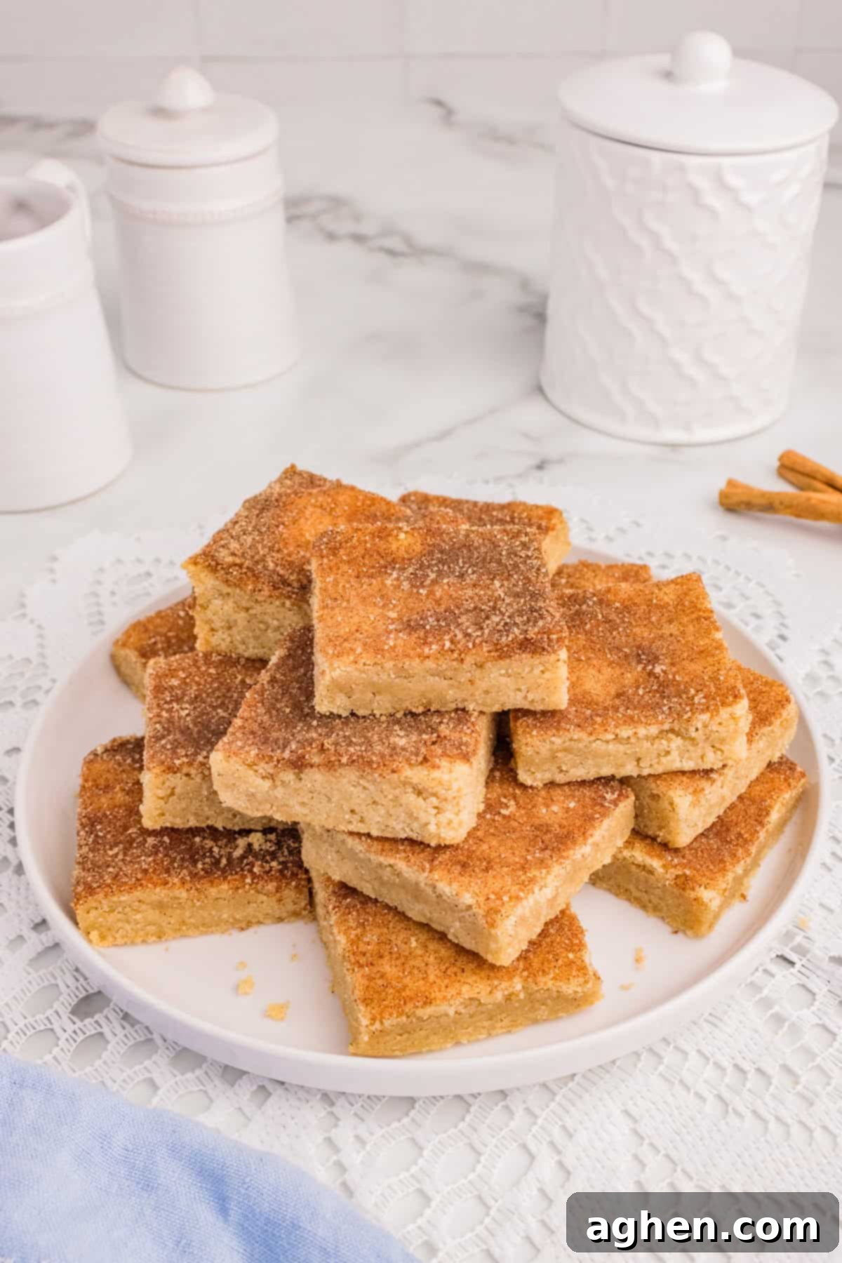 Snickerdoodle Cookie Bars sliced into squares and piled on serving plate.