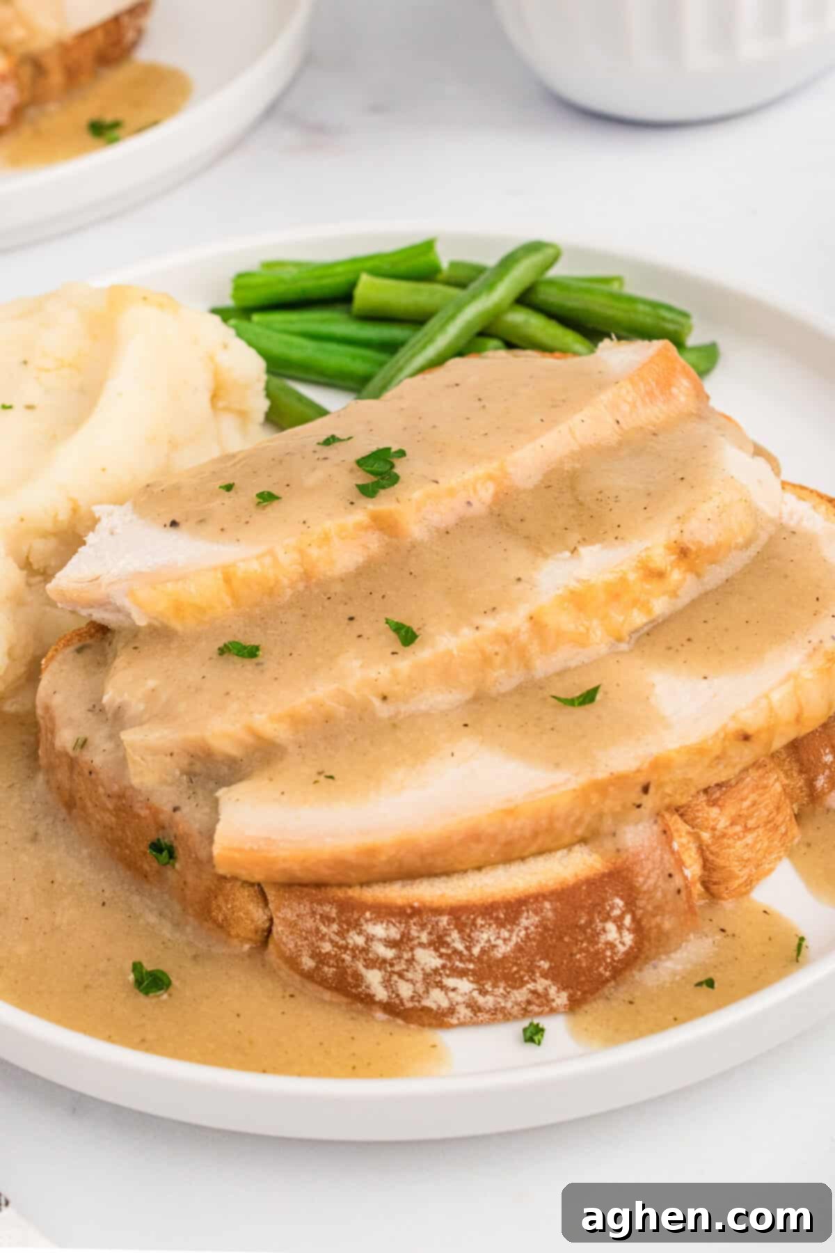 Open Faced Turkey Sandwich 2 Hot open faced turkey sandwich made with leftover roast turkey, smothered in gravy and served on toasted bread with parsley garnish and alongside green beans and mashed potatoes.
