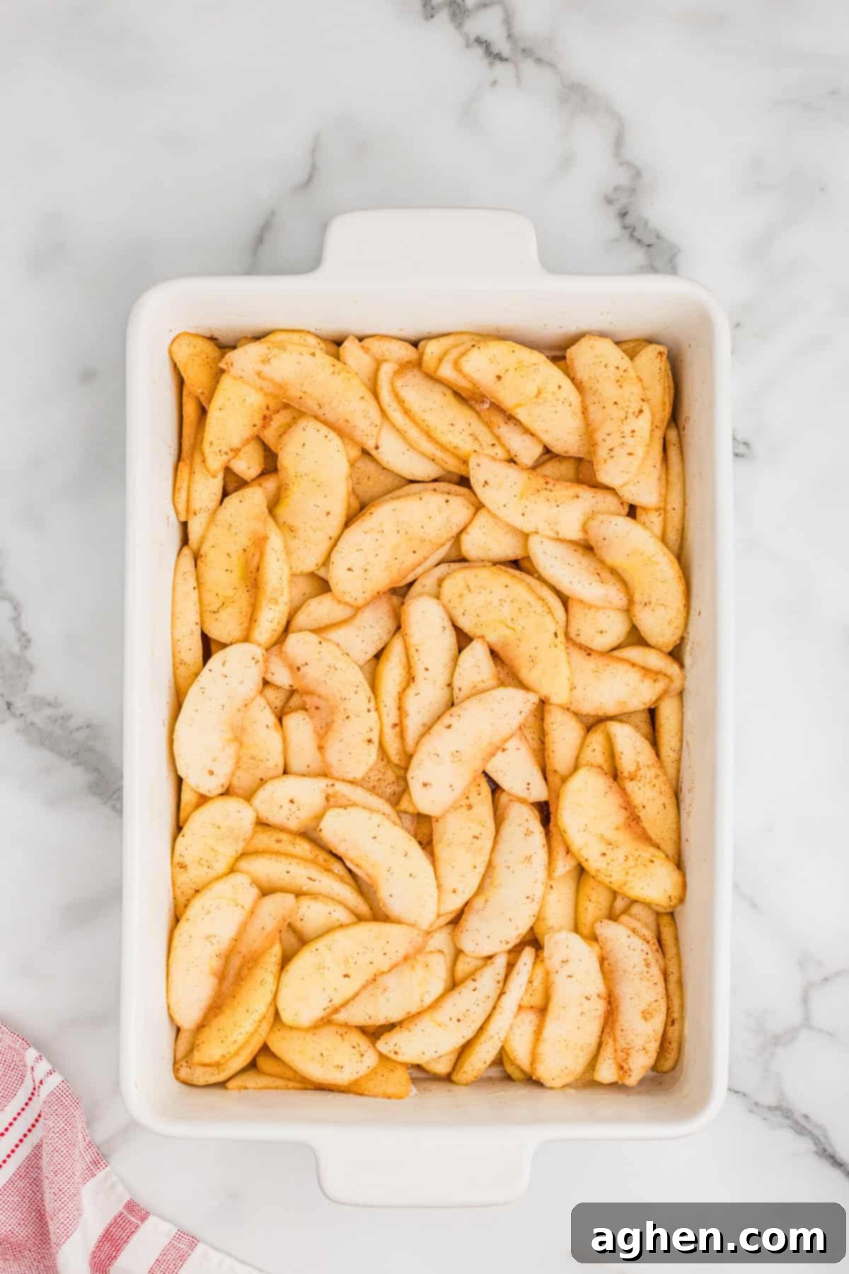 Peeled and sliced apples, coated in cinnamon and sugar, and spread evenly into a 9x13 baking dish.